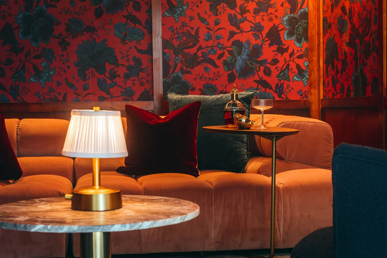 Velvet sofa and brass sconce detail in moody library, Flamingo Point residence Miami Beach