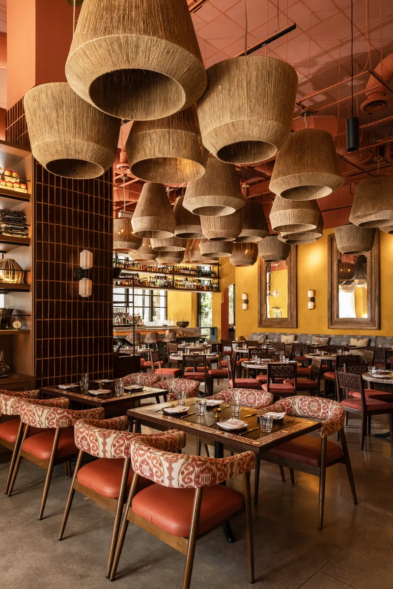 Ghee Indian Kitchen dining room with spice market shelf and warm textiles, Wynwood Miami