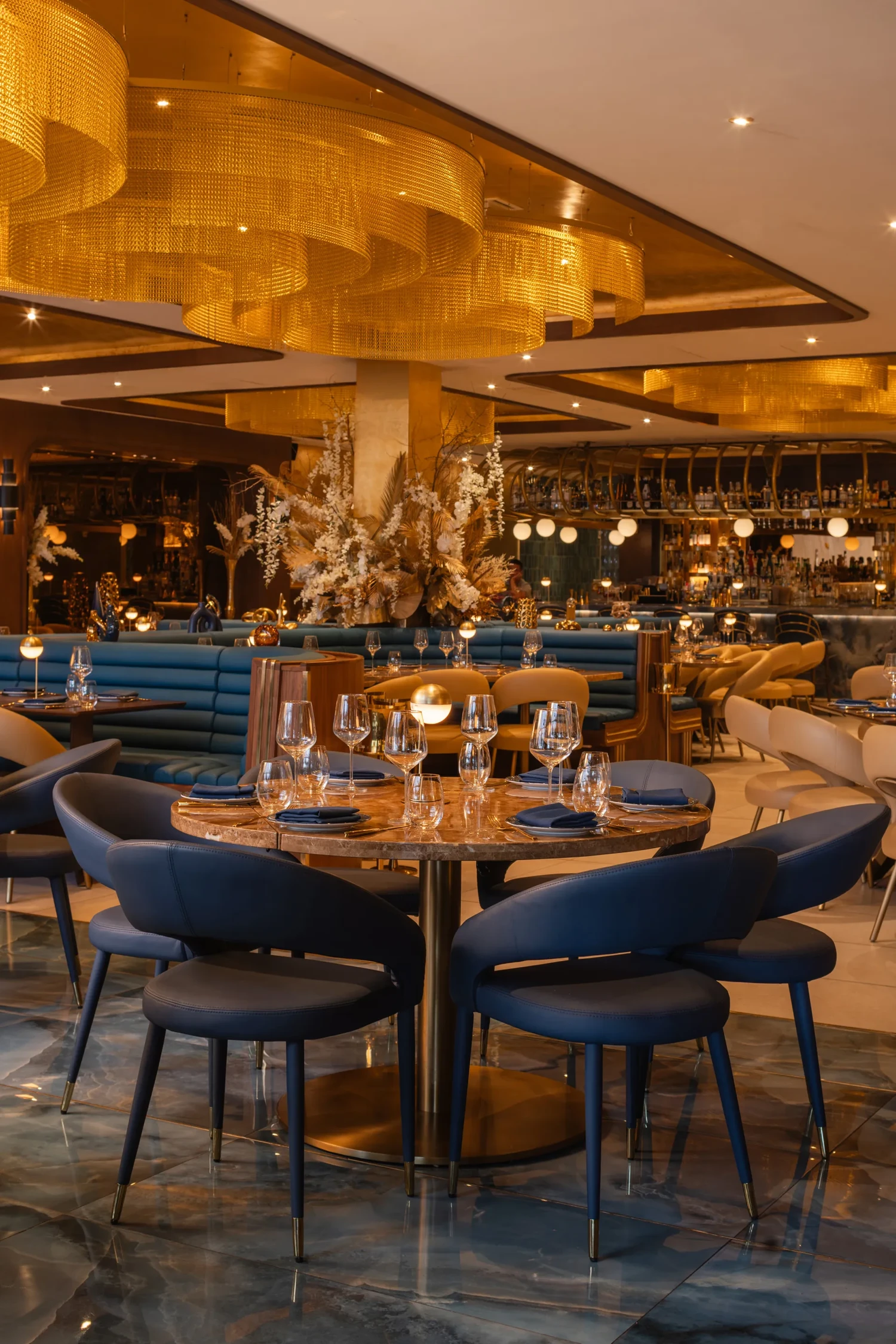 Brass fixtures and blue leather banquette seating at Oro restaurant, Miami Beach