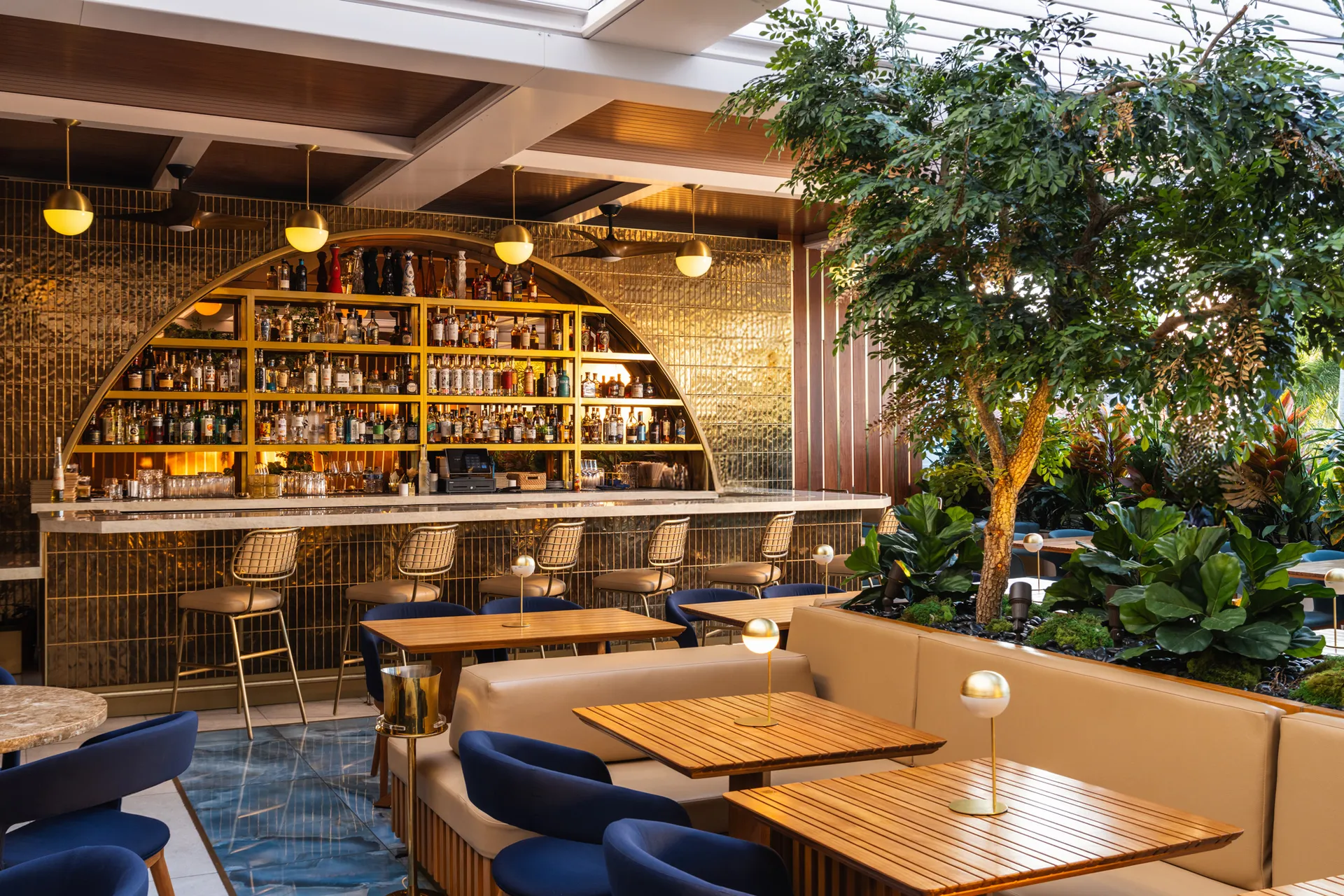 Marble-topped bar with brass accents at Oro steakhouse, Miami Beach restaurant design