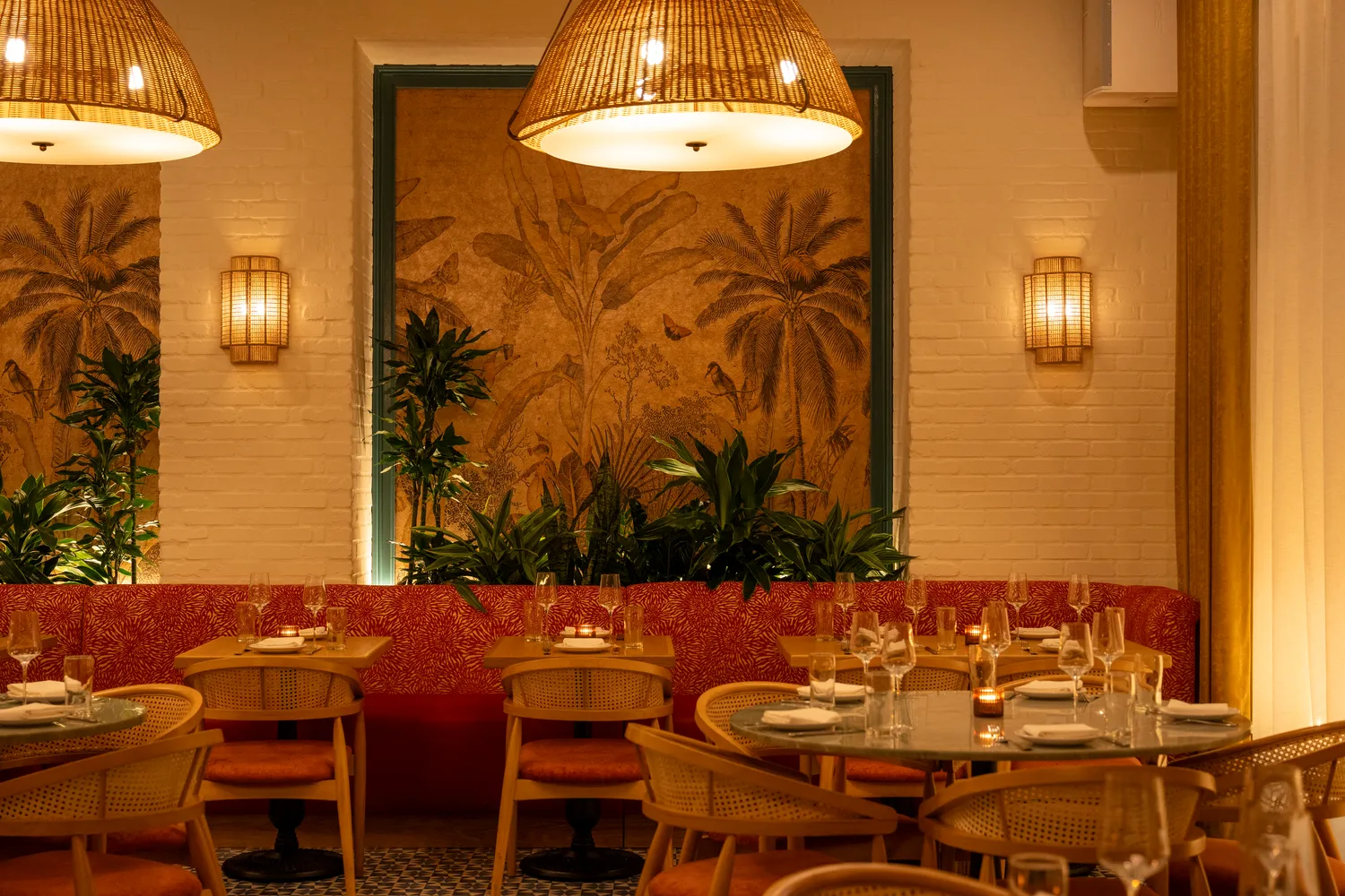 Plant-lined banquettes and gold wallpaper at Paya, Miami Beach restaurant interior design